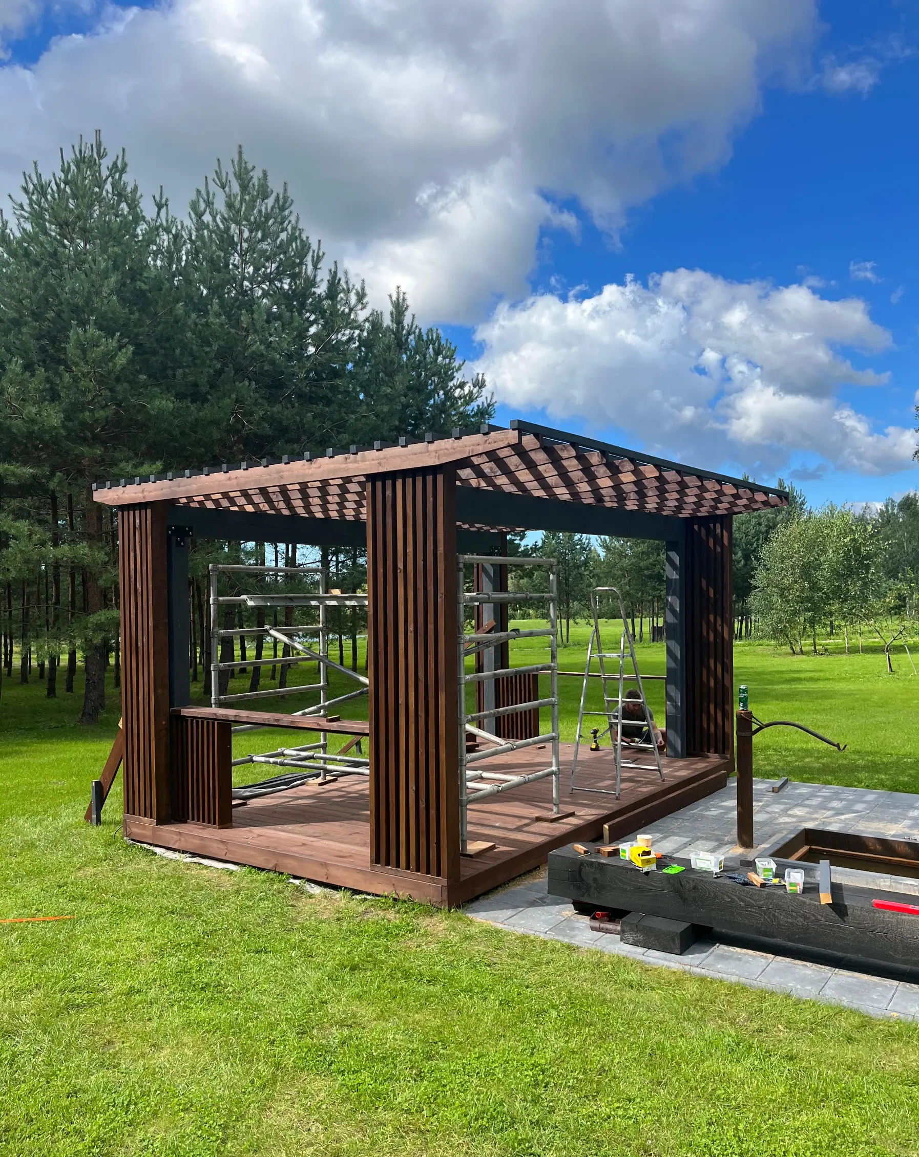 Attēls, kurā ir nojume, kuru būvē ar iebūvētu virtuves salu dārzā